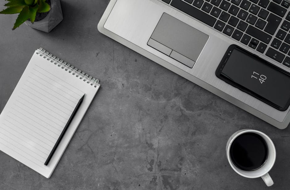 A modern office setting with a desk phone and a notepad filled with voicemail message examples.