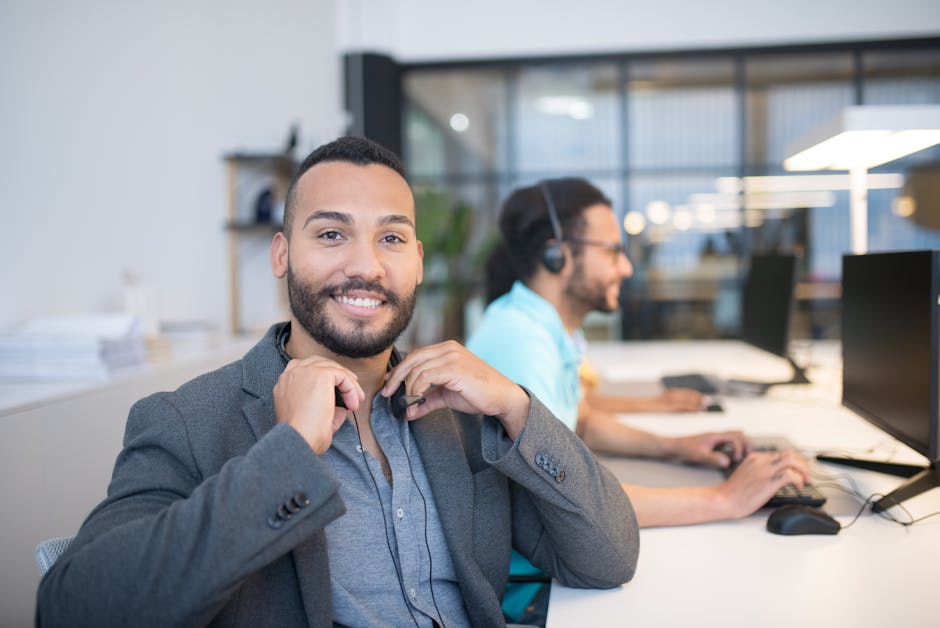A vibrant office setting where employees are engaged in virtual calls with clients, showcasing a blend of technology and teamwork.