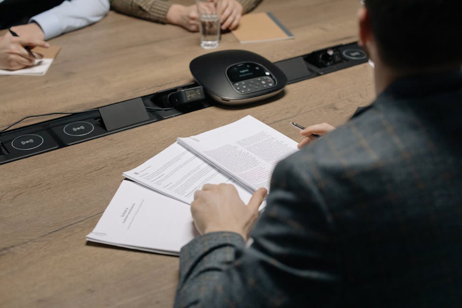 A team collaborating around a conference table, reviewing call forwarding strategies and communication protocols.