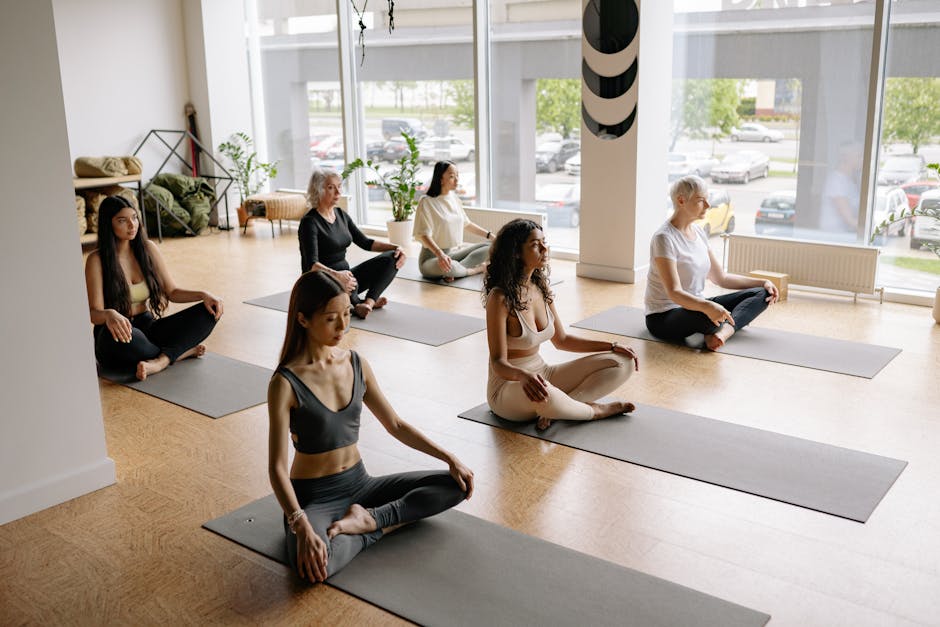A peaceful yoga studio with soft lighting and serene design, showcasing a diverse group of students practicing yoga.