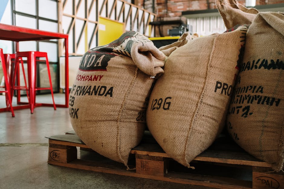 A steaming cup of artisan coffee surrounded by coffee beans and sustainable packaging materials, showcasing the blend of tradition and modernity in the specialty coffee business.