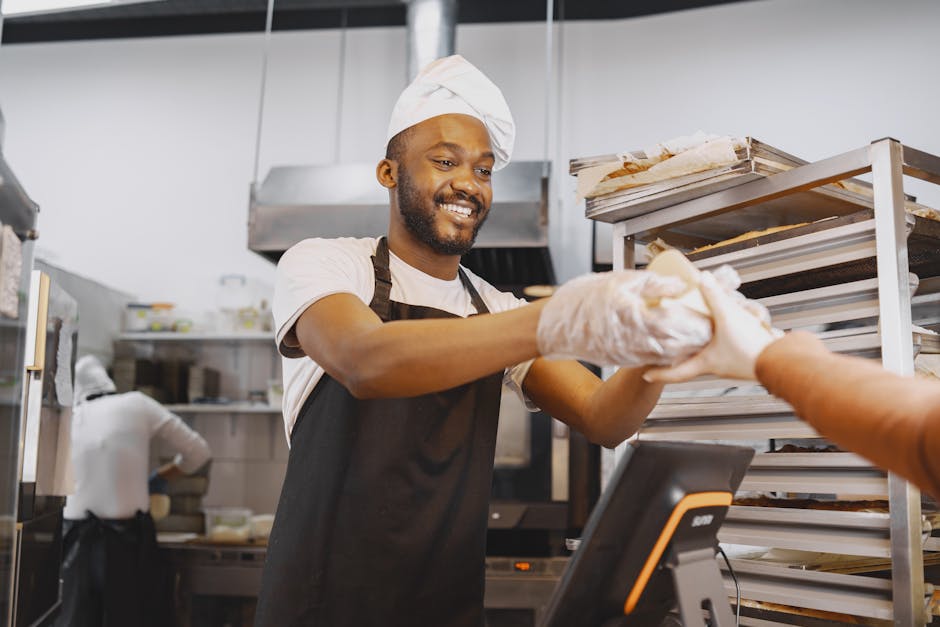 Image of a baker discussing options with a customer over the phone, surrounded by fresh baked goods.