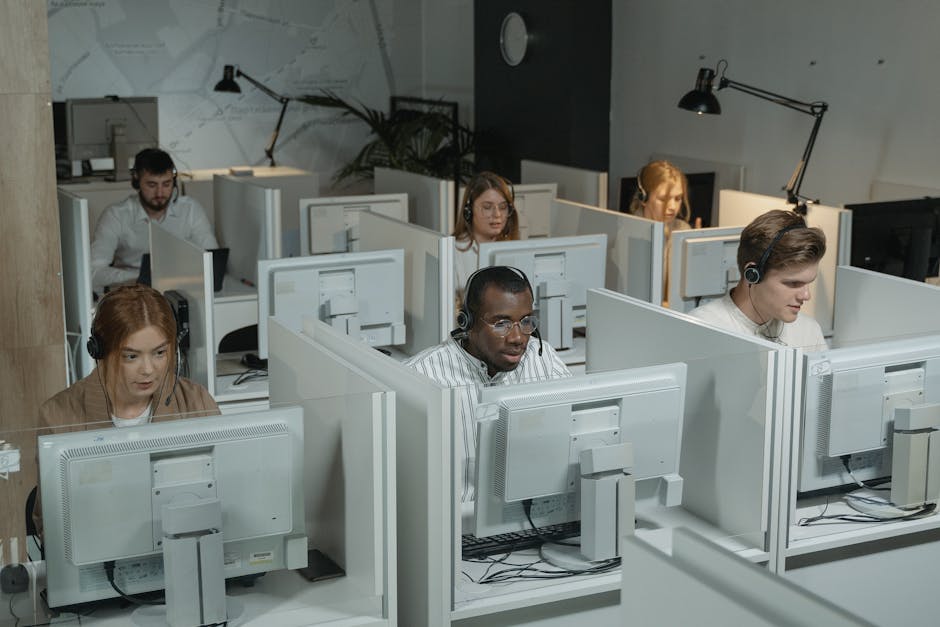 A futuristic office setting where teams are engaged in discussions with the assistance of advanced technology showcased on their screens.