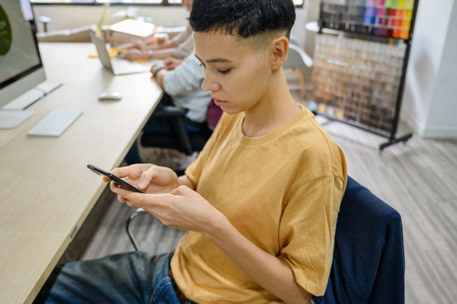 A dynamic office scene where a real estate agent receives a text on their phone, which is seamlessly forwarded to an email inbox on their computer screen.
