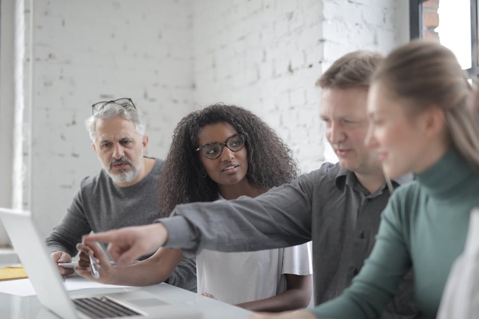 A modern office environment showcasing a diverse group of professionals collaborating with AI technology, emphasizing communication and teamwork.
