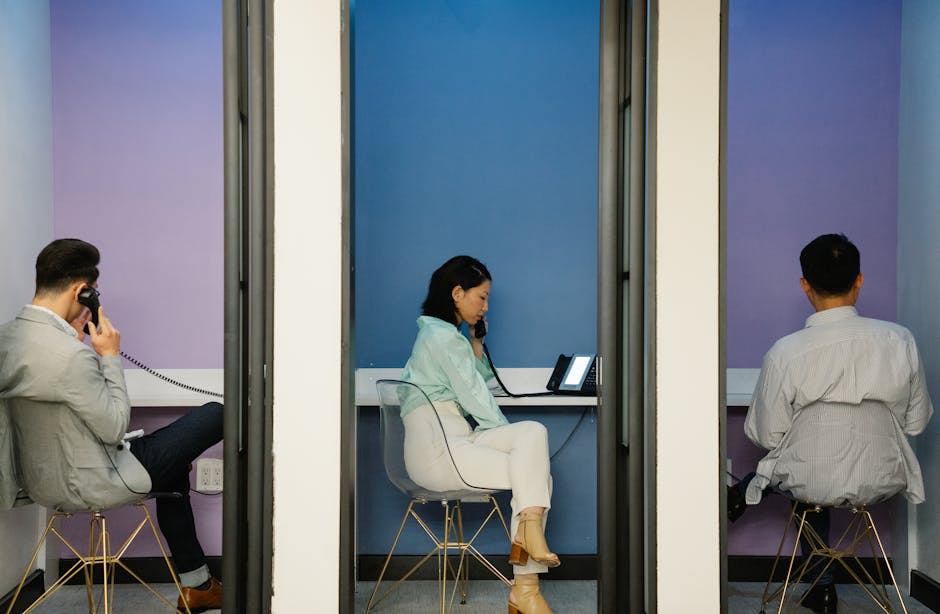 A dynamic office scene showing a team engaging in a conference call using both landlines and cell phones, emphasizing connectivity and collaboration.