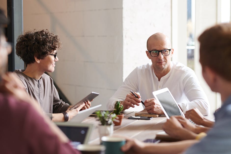 A bustling office scene where employees interact with AI technology on their screens, showcasing modern communication solutions.