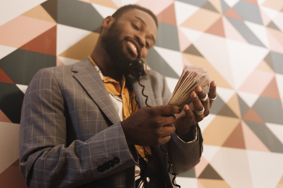 A business professional holding a smartphone, with a landline in the background, symbolizing the transition from landline to cell communication.