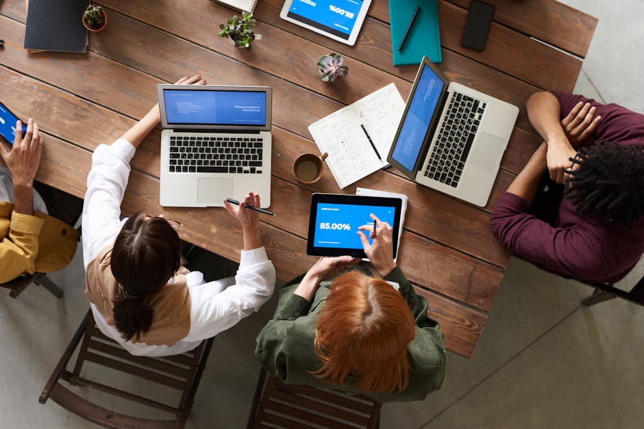 A business team in a modern office discussing insights from call recordings, surrounded by digital devices and analytics.