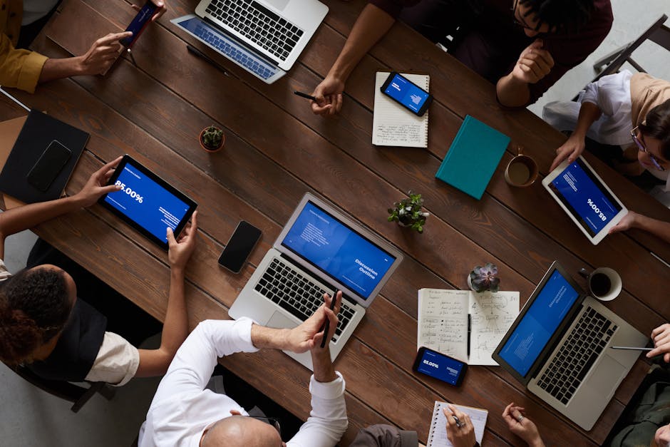 A dynamic image showing a business team discussing telecommunication strategies with smartphones and laptops on the table.