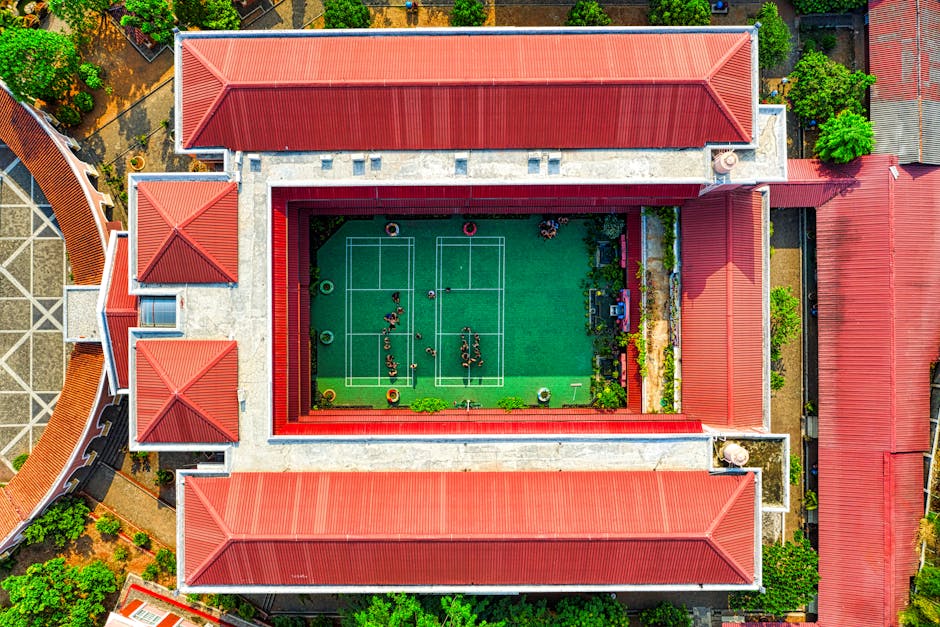 An aerial view of a vibrant green roof atop a commercial building, showcasing diverse plant life and people enjoying the space.