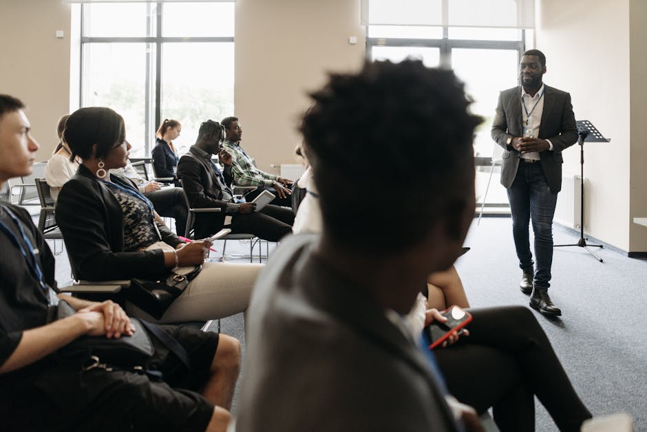 A diverse group of professionals in a modern office setting, engaging in a phone communication training session, showcasing enthusiasm and professionalism.