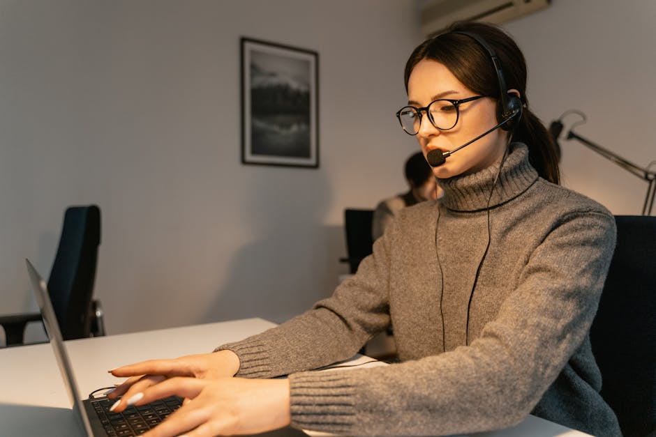 A professional phone agent assisting a customer with a computer repair inquiry, set in a modern office environment.