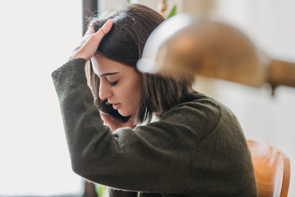 A frustrated individual making a phone call about their insurance claim, with visible signs of impatience.