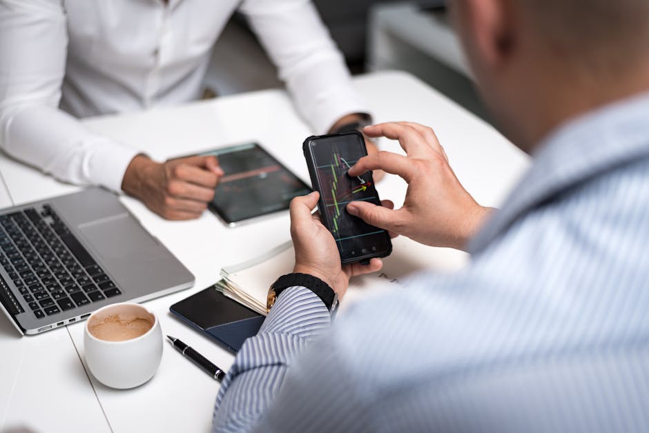 A professional environment with a person using a smartphone while discussing business, demonstrating the importance of seamless communication.
