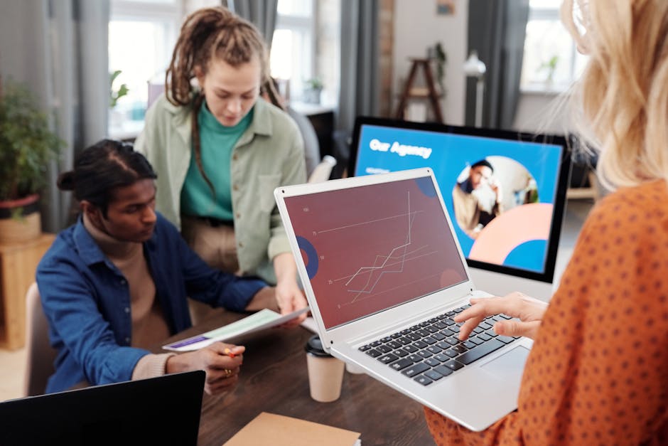 A group of diverse employees collaborating at a conference table, analyzing data from AI tools on a screen