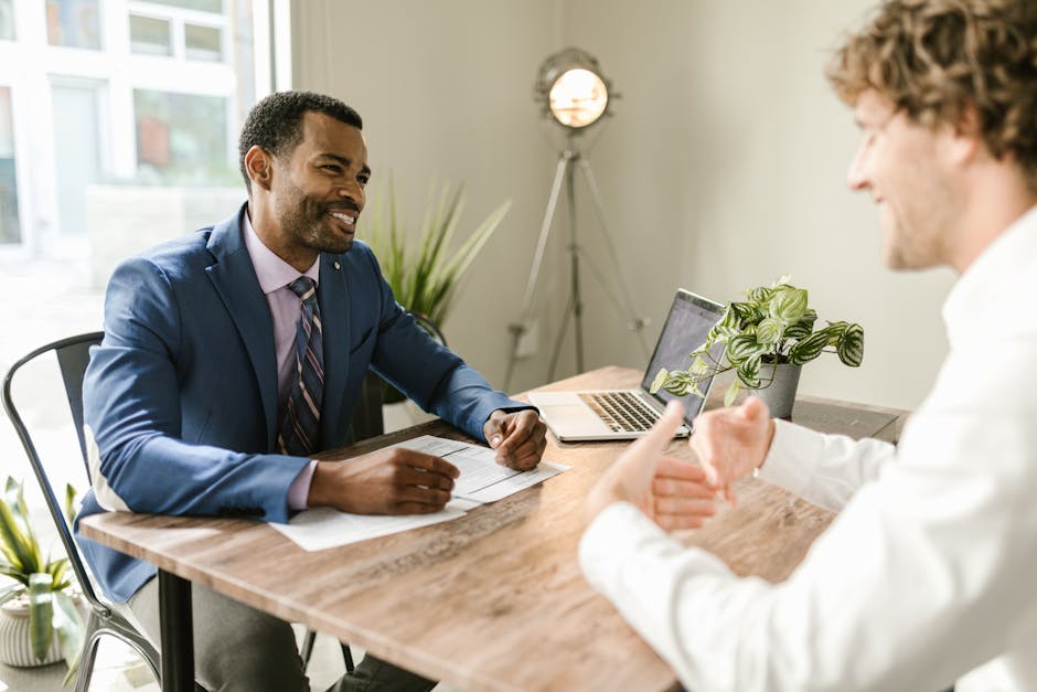 A friendly phone agent speaking with a homeowner in a cozy, well-lit office with remodeling plans displayed on the desk.