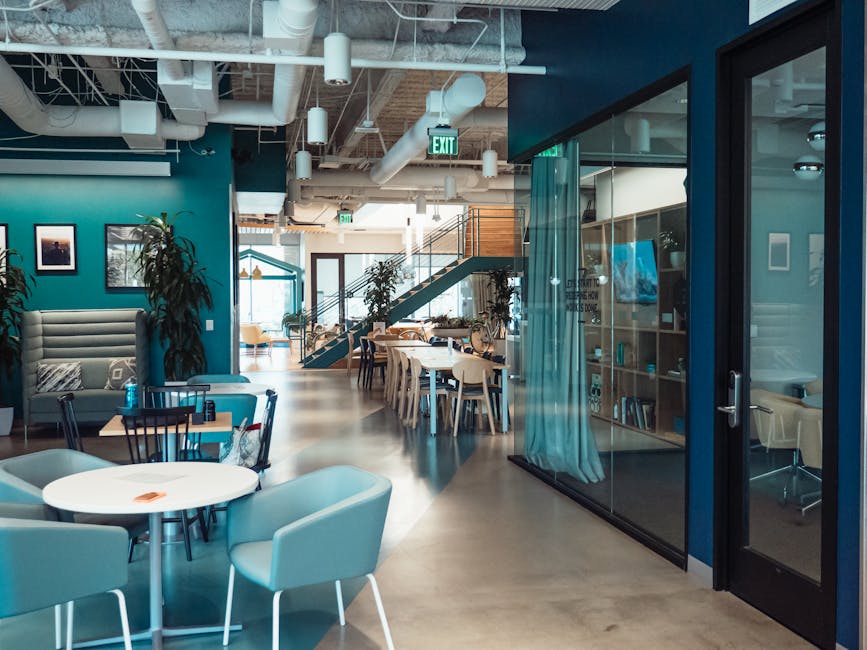 A modern interior design office with a team analyzing client data and sketches, showcasing collaboration.