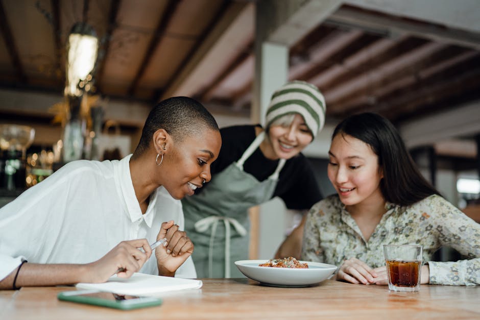 A group of diverse individuals engaged in a training session, practicing customer service skills over phone calls, surrounded by meal prep materials.