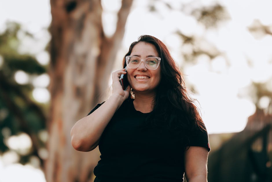 A friendly phone agent smiling while engaging in a conversation with an RV enthusiast, with RVs visible in the background.