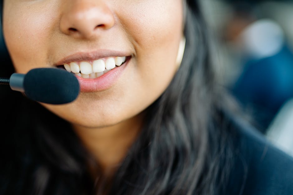 Image of a friendly plumbing agent speaking on the phone in a cozy office environment, with plumbing tools visible in the background.