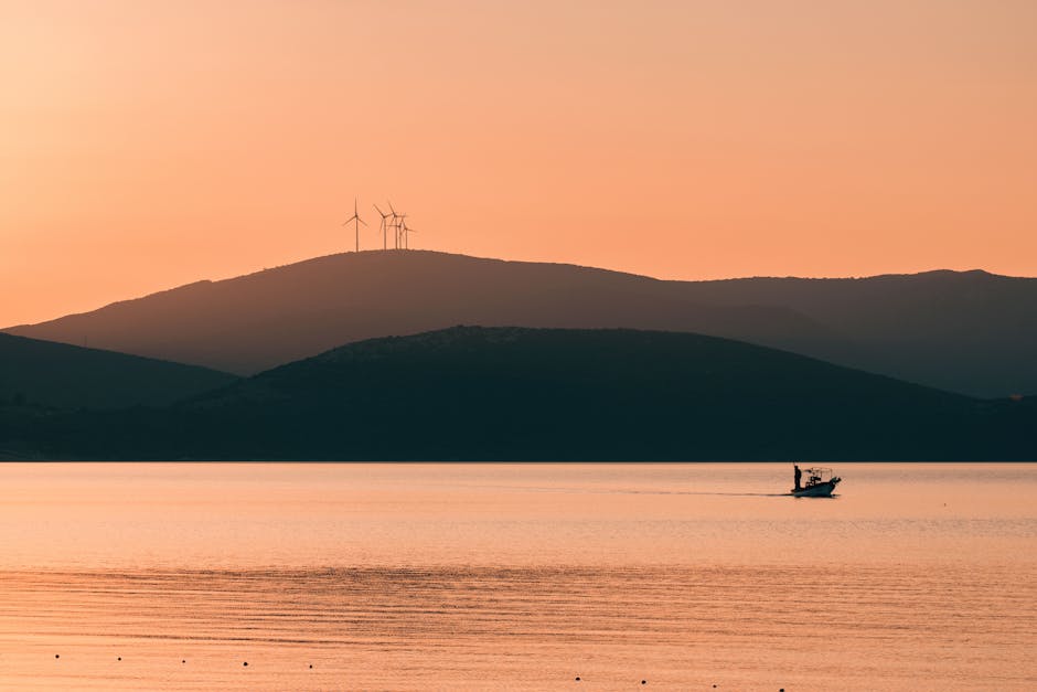 A wind turbine maintenance agent on the phone, with turbines in the background, demonstrating a professional and approachable demeanor.