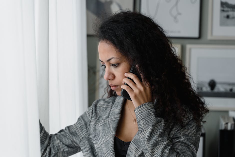 A representative phone agent engaged in a conversation with a client, in a modern office setting with accounting materials visible.