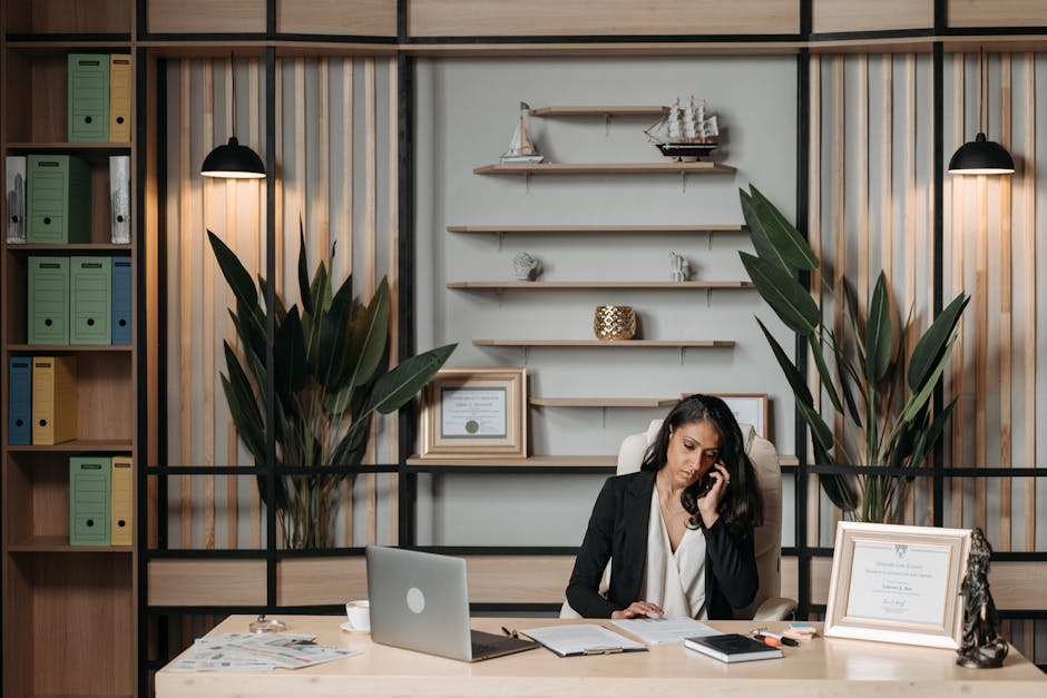 A professional phone agent at a desk, engaging with a client over the phone, showcasing a welcoming office space with legal books and soft lighting.