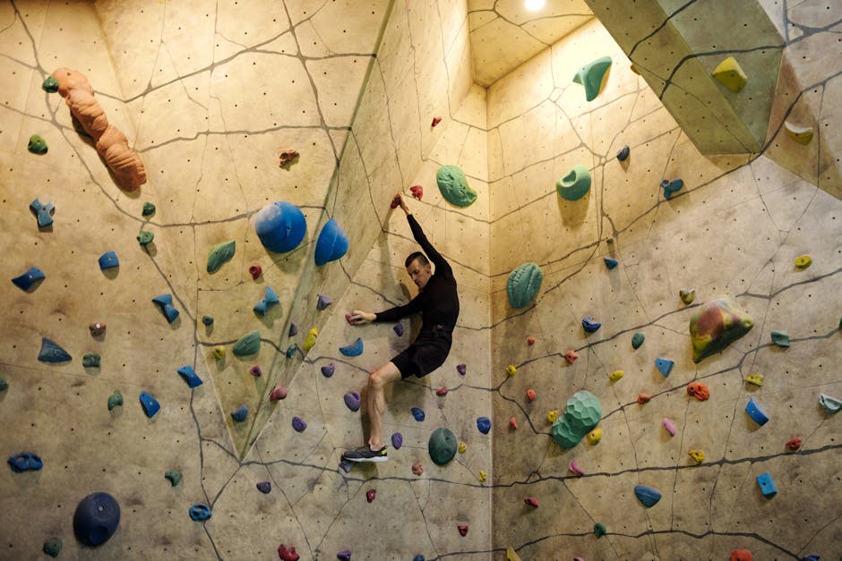 An inviting indoor rock climbing gym setting showing people of various skill levels engaging with the sport.