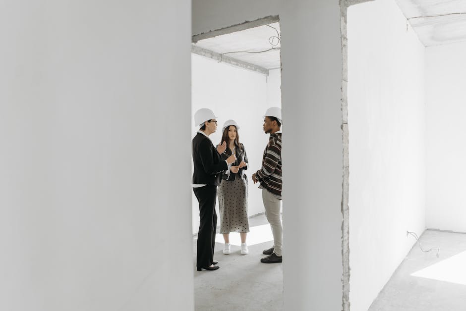 A phone agent engaged in a focused conversation with a potential construction client, surrounded by construction plans and digital tools.