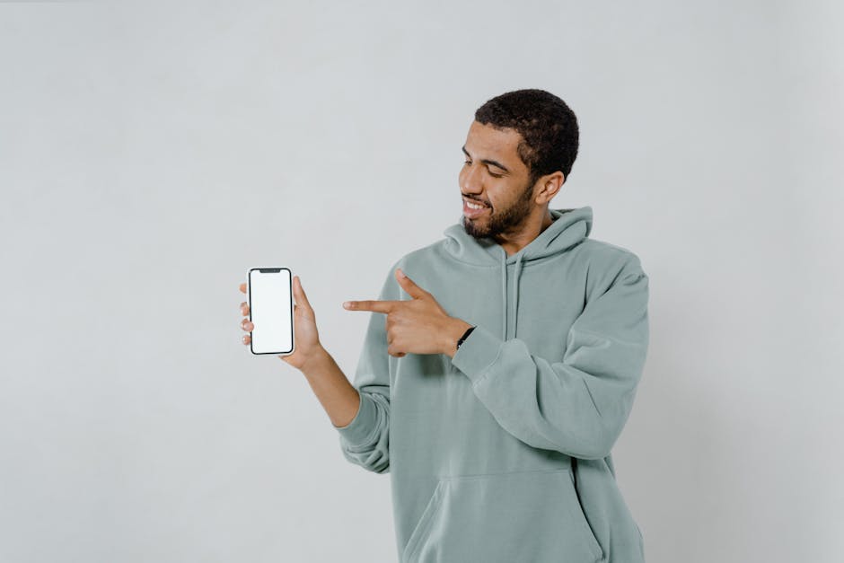 A photographer holding a smartphone, showing SMS interactions with clients in a bright, welcoming studio environment.