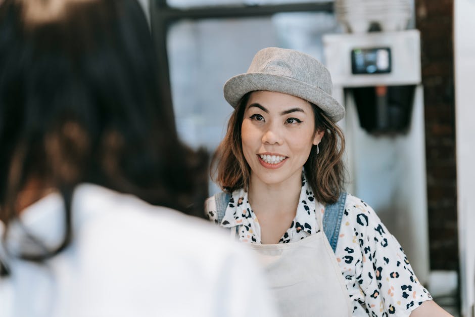 A warm and inviting nail salon environment featuring cheerful staff interacting with a customer over the phone, illustrating customer service and engagement.