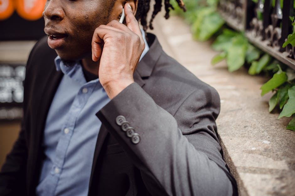 A healthcare worker using an automated calling system, surrounded by supportive technology, with patients engaged in conversation in the background.