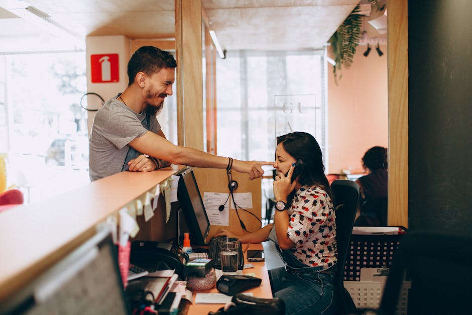 A friendly and inviting office environment with a receptionist answering the phone, showcasing personal interaction.