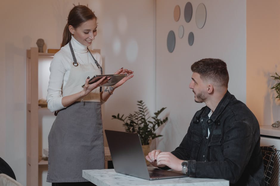 A cozy café scene featuring a barista interacting with customers using a tablet, showcasing a modern customer service approach with technology.
