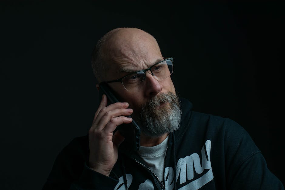 A person listening to a voicemail on their phone with a thoughtful expression, indicating they are assessing the clarity and tone.