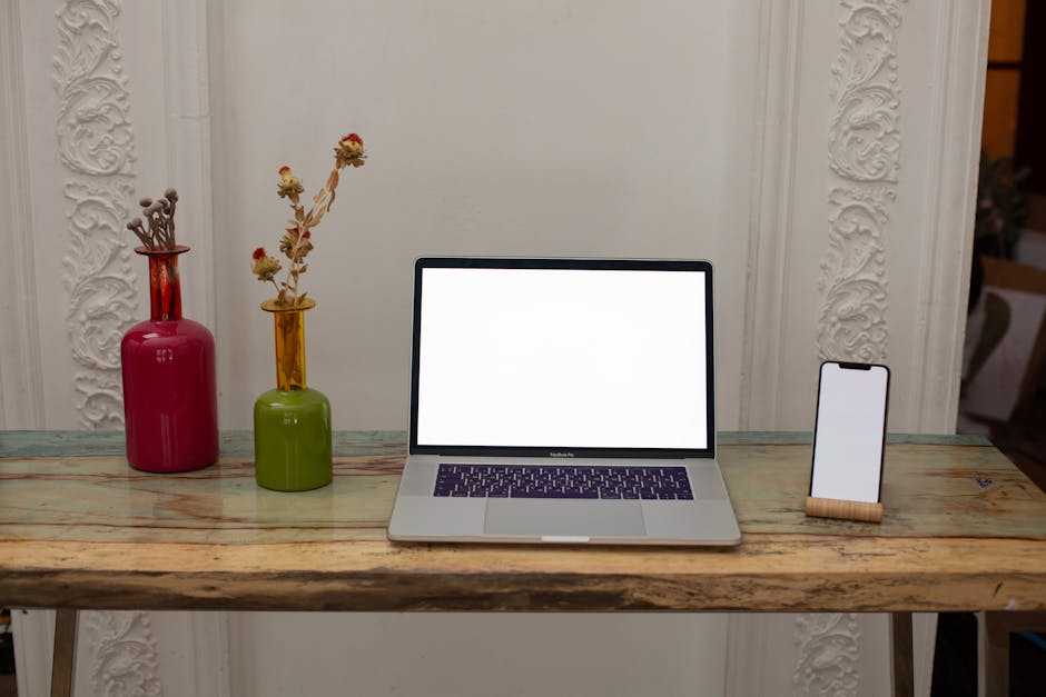A stylish Bluetooth headset prominently displayed against a desk with a laptop and notepad, emphasizing a professional setup for phone calls.