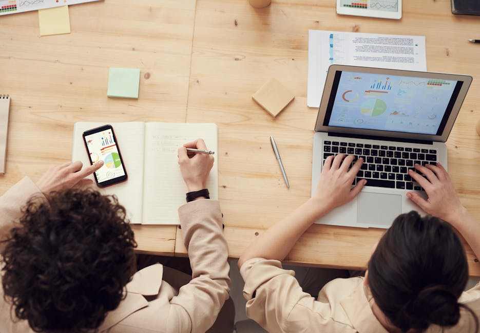 A team in an office setting collaborating over a phone call with visual aids and digital devices showcasing communication tools