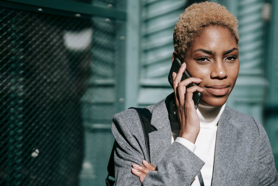 A businessperson speaking on the phone with a confident demeanor, surrounded by modern technology that symbolizes enhanced communication.