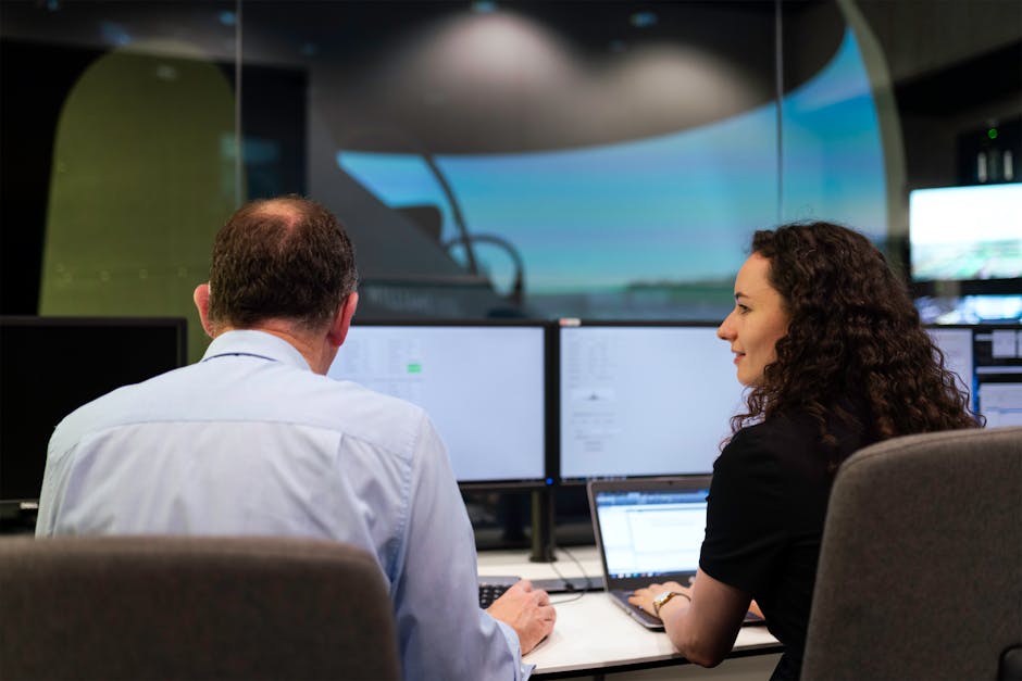 A modern office environment with a digital receptionist display interface and diverse employees interacting with it.