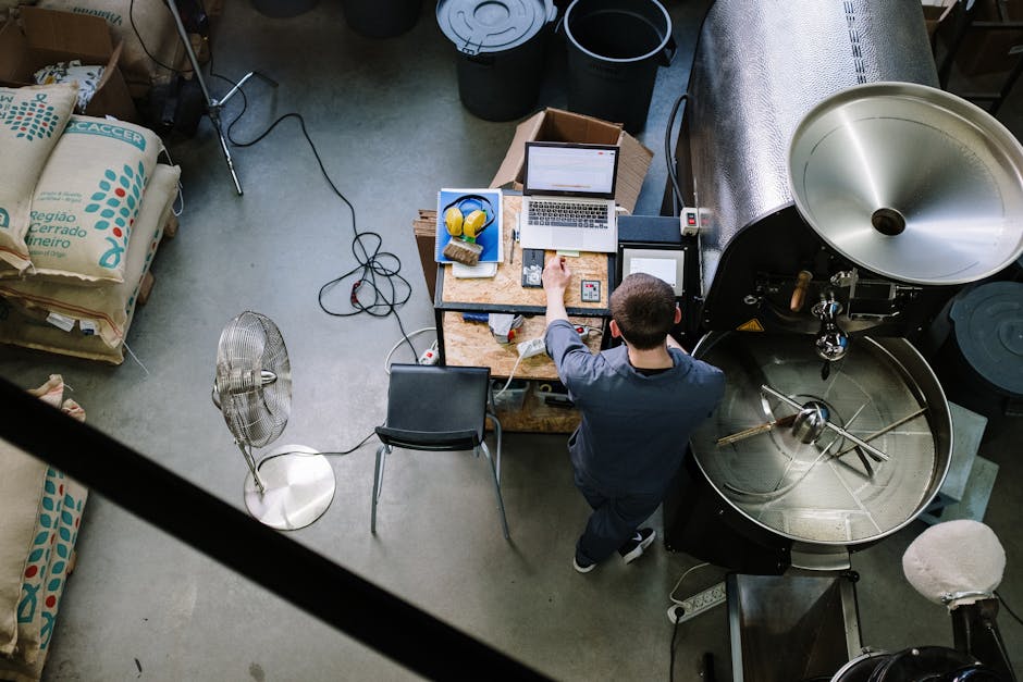 Image of a well-organized specialty coffee roasting facility, with roasters and bags of green coffee beans, showcasing both the equipment and the roasting process.