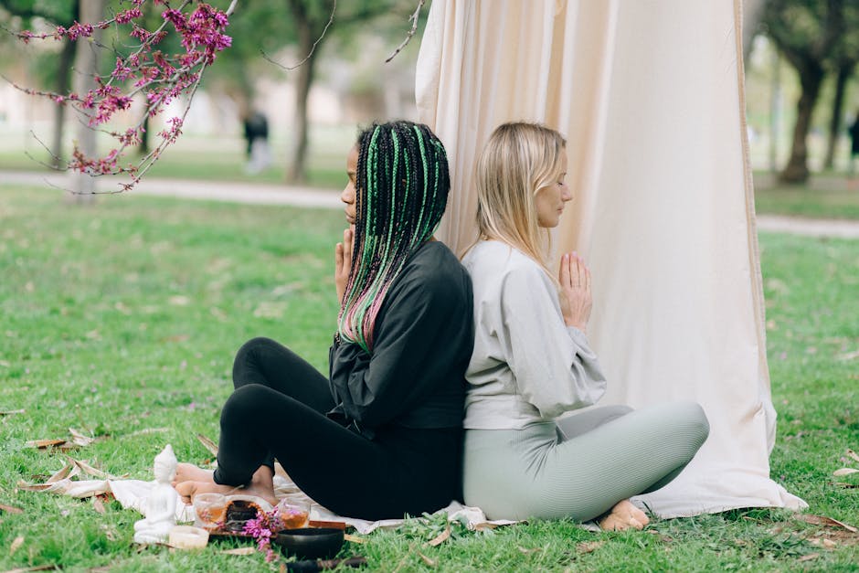 A vibrant community yoga class in action, with students practicing poses outdoors in a serene park setting